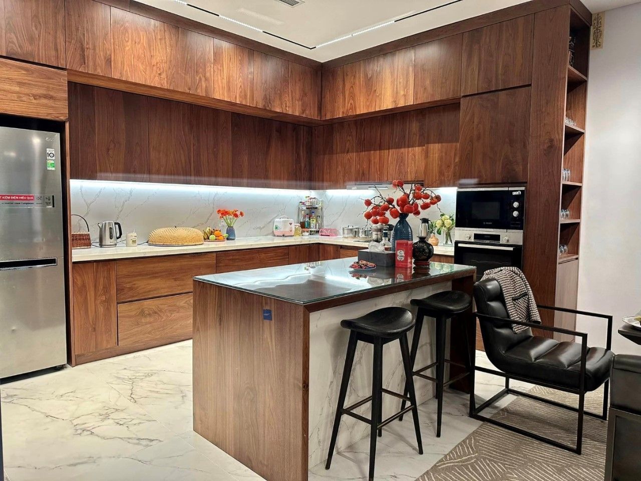 Phòng bếp hiện đại với tủ bếp gỗ tự nhiên sang trọng, có bàn đảo bếp rộng rãi