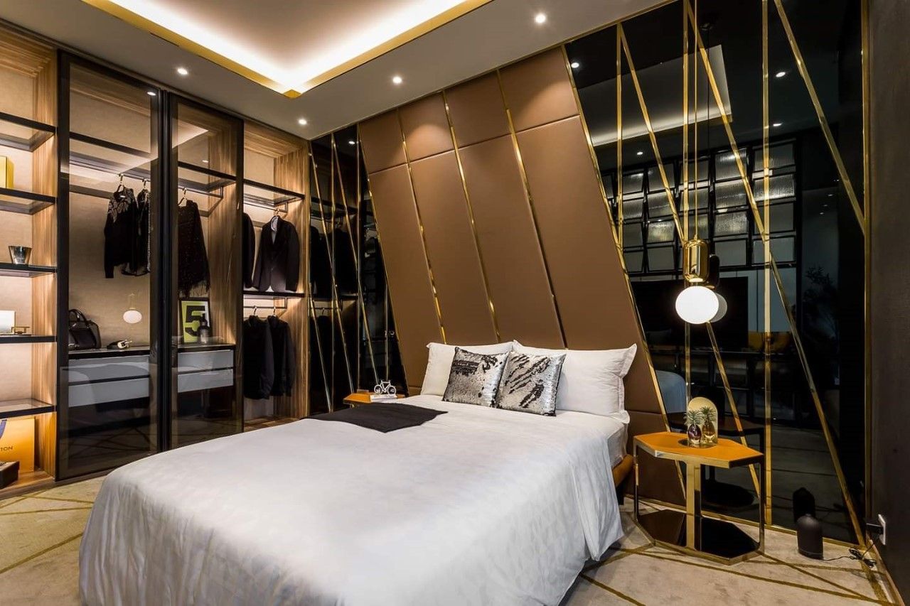 Phòng ngủ thiết kế theo phong cách sang trọng với điểm nhấn là vách đầu giường ốp nệm da cùng kính đen chạy chỉ vàng khiến căn phòng trở nên đẳng cấp hơn
