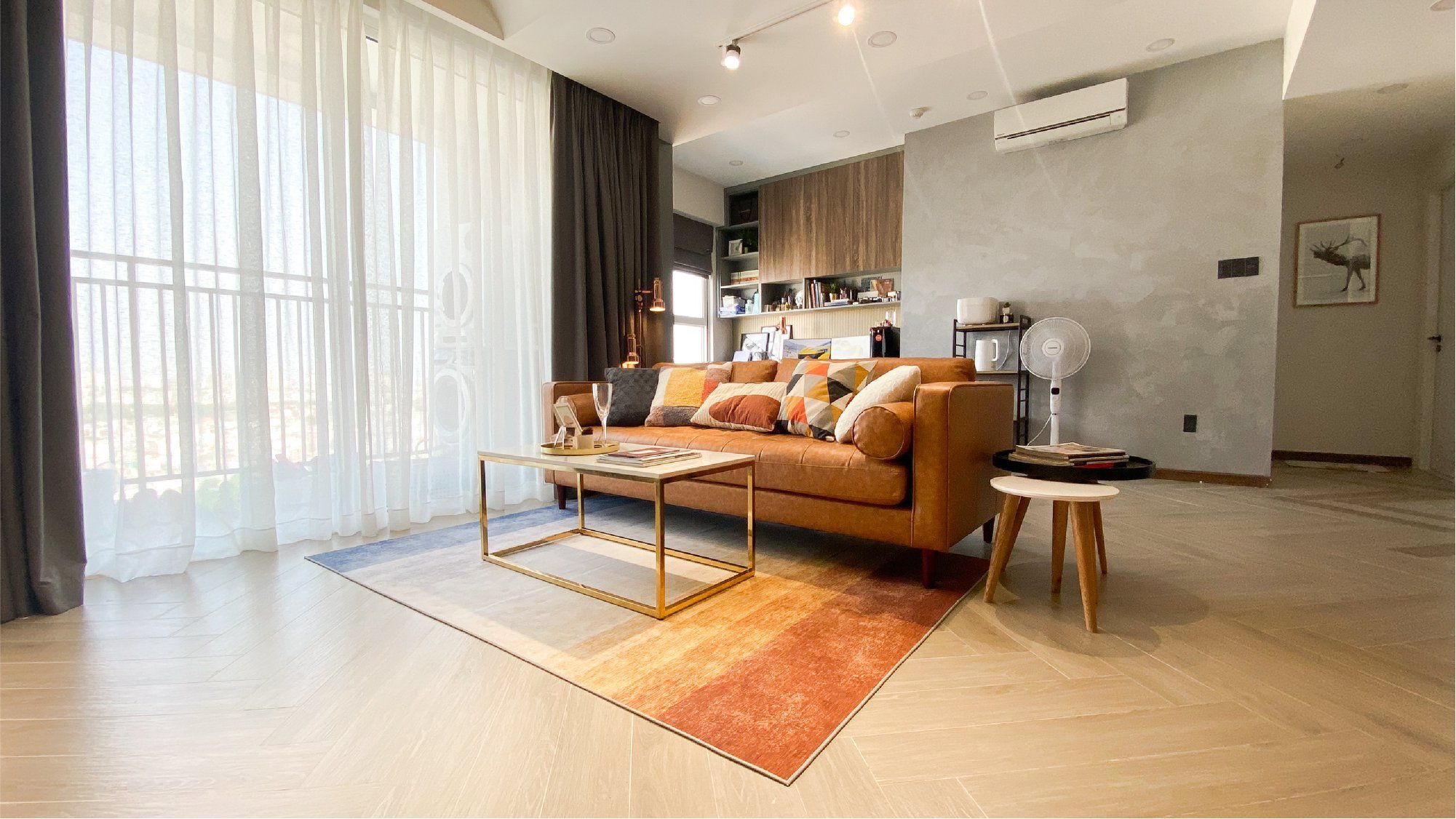 Phòng khách rộng rãi sử dụng sofa da màu cam làm điểm nhấn kết hợp bàn trà phối chân vàng