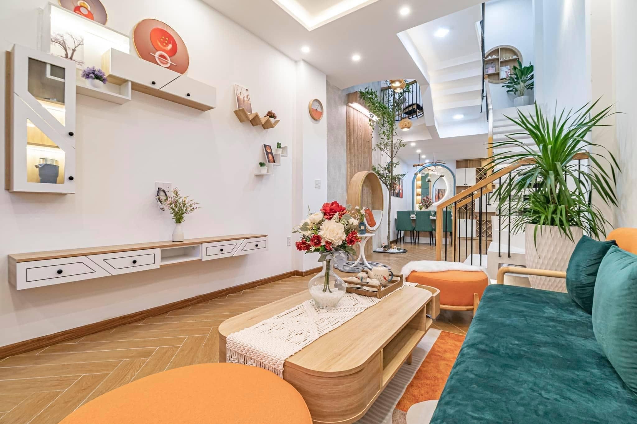 Phòng khách hiện đại sử dụng nội thất gam màu cam, xanh nổi bật làm điểm nhấn thú vị với tủ tivi lạ mắt, độc đáo