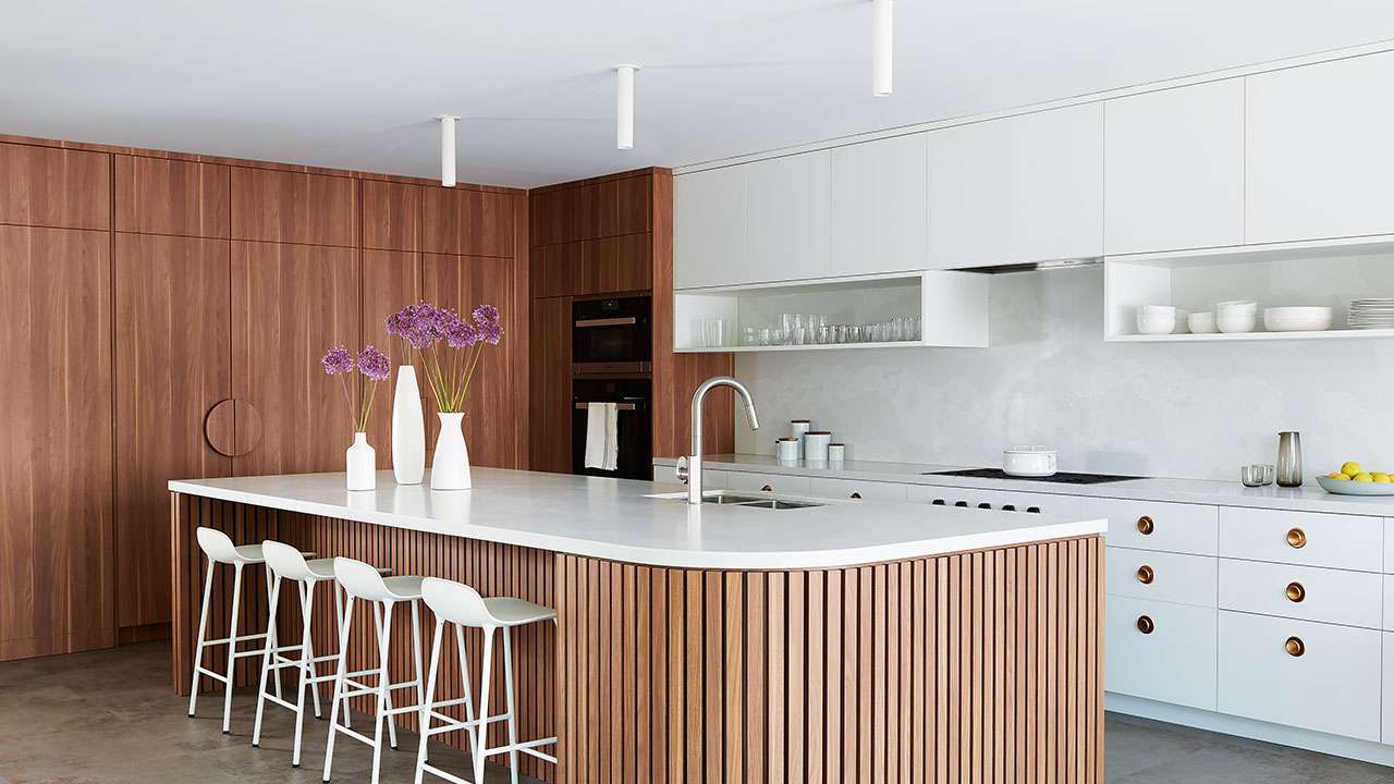 Đảo bếp sử dụng tone màu trắng kết hợp với gỗ tạo nên vẻ sang trọng, hiện đại