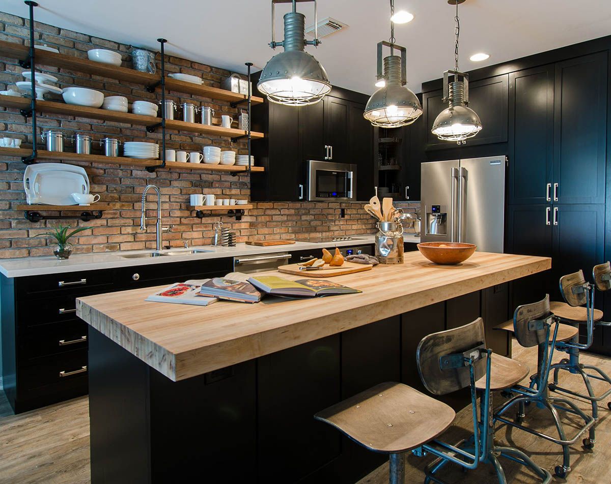 Phòng bếp Industrial với bàn ăn bằng gỗ thô và ghế kim loại đen.