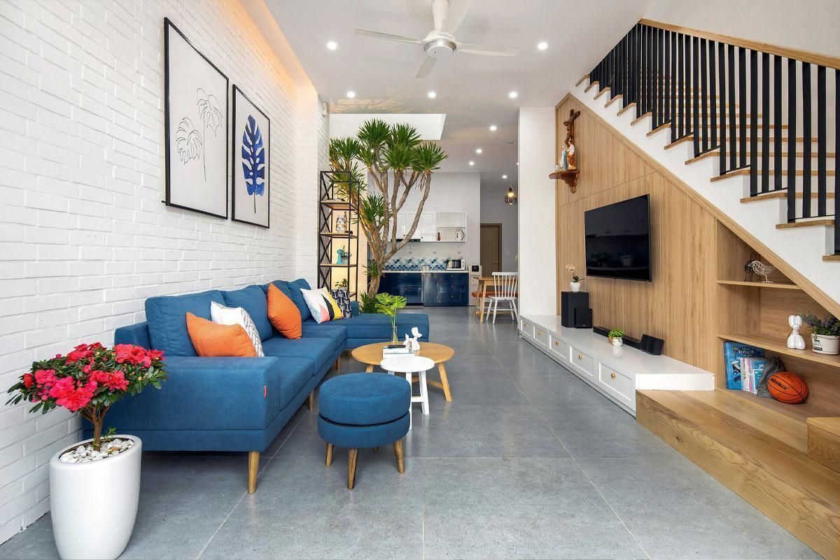 Phòng khách nhà ống 4m tận dụng gầm cầu thang làm tủ đựng tivi tích hợp kệ trang trí