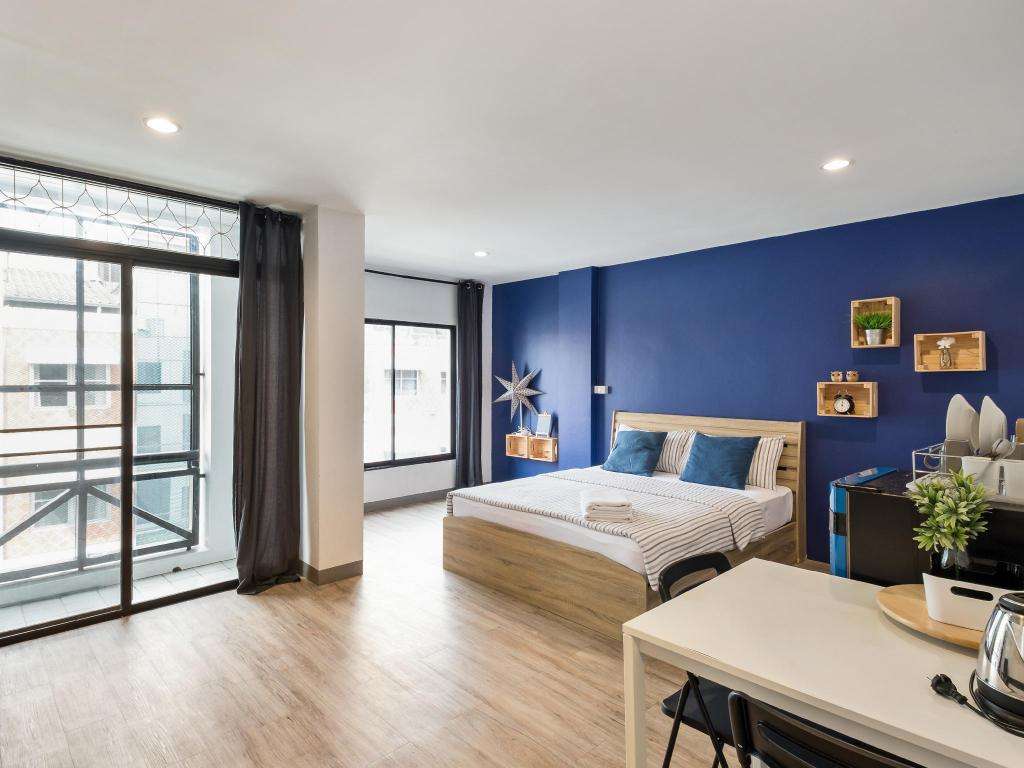 Trần thạch cao phẳng màu trắng hòa hợp với sắc xanh của căn phòng ngủ.